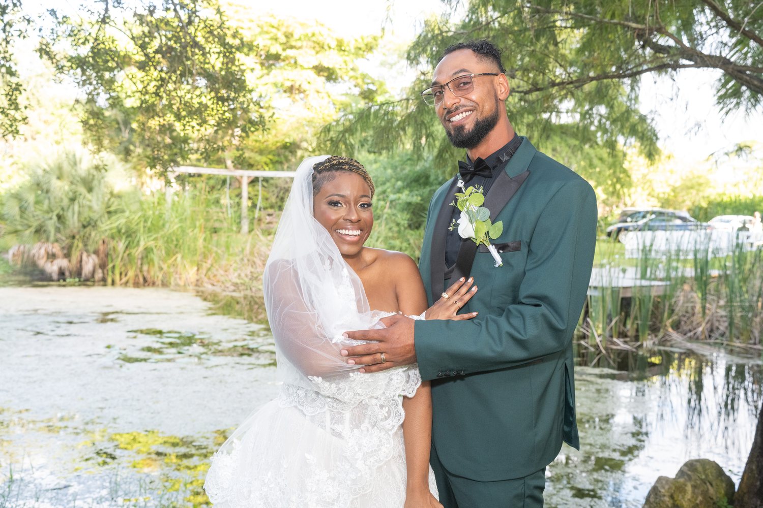Bride and groom pond portrait green tuxedo